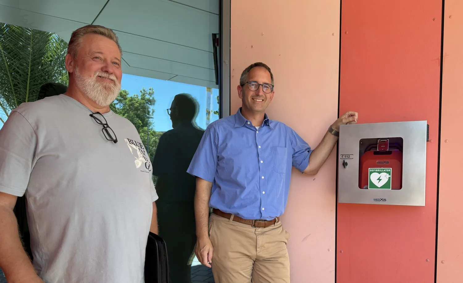 OB Sebastian Frei und Wilhelm Hitsch vom Hochbauamt mit dem Defibrillator am Haupteingang des Kurhauses Bad Rappenau (Bild: Stadt Bad Rappenau)